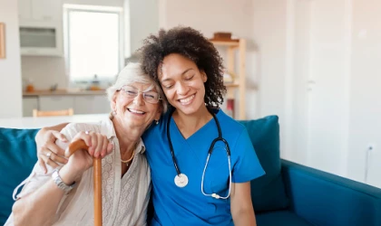 Lady and Nurse hugging on sofa